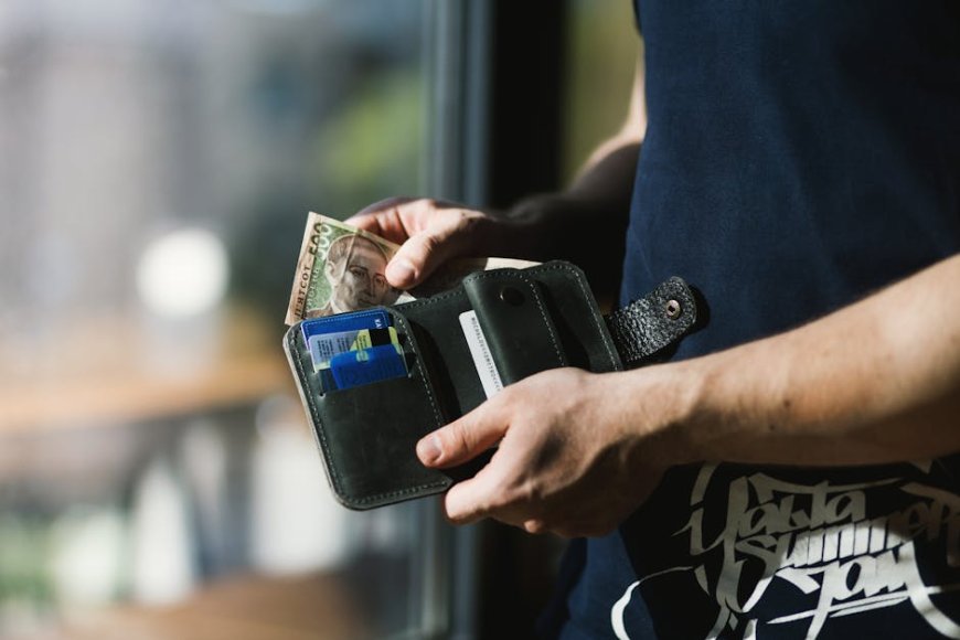a person managing daily expenses with budgeting app and cash envelopes on a desk in natural lighting